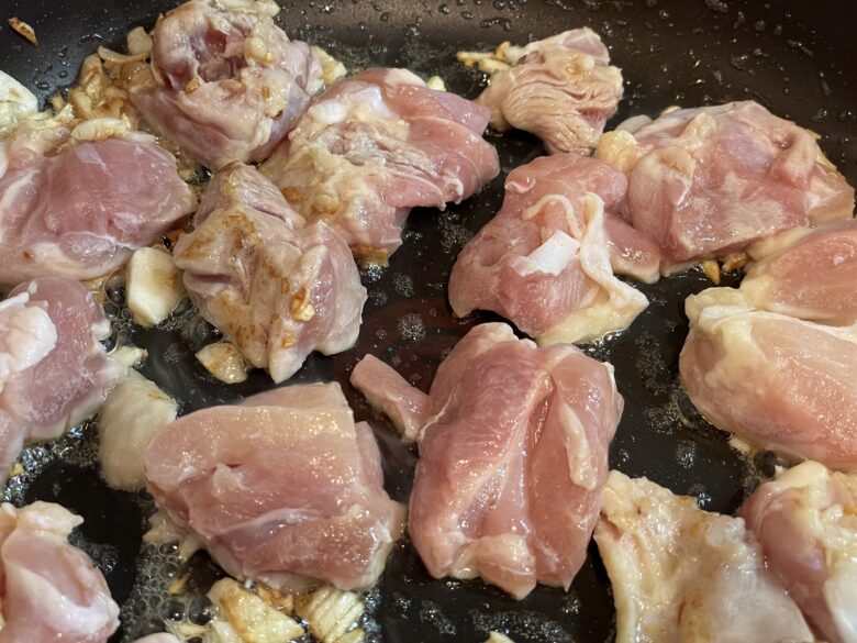 にんにくと鶏肉を炒める